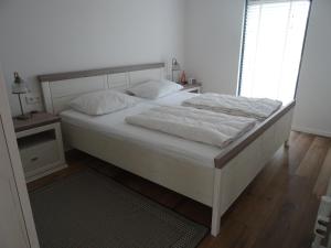 een bed met witte lakens en kussens in een slaapkamer bij Kustverhuur, Park Schoneveld, Zeester 49 in Breskens