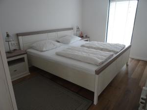 a bed with white sheets and pillows in a bedroom at Kustverhuur, Park Schoneveld, Zeester 49 in Breskens