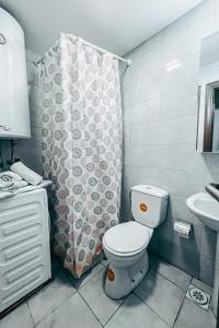 ein Bad mit einem WC und einem Duschvorhang in der Unterkunft He-Ra apartment 6 with Free Netflix in Skopje