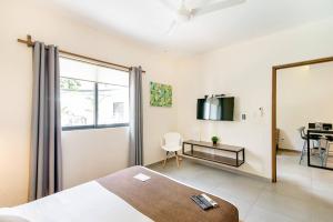 1 dormitorio con cama, espejo y escritorio en Viento Suites Cancún en Cancún