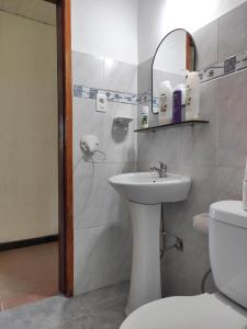 a bathroom with a sink and a toilet and a mirror at Casa playa hermosa 3 dormitorios in Playa Hermosa