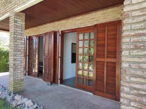 a house with wooden doors and a patio at Casa playa hermosa 3 dormitorios in Playa Hermosa