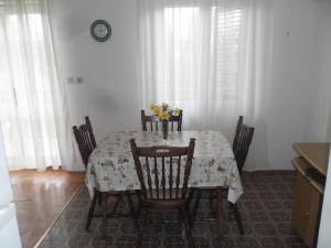 a dining room table with chairs and flowers on it at Apartments Ajka in Tisno
