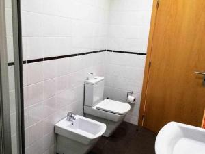 a bathroom with a toilet and a sink at Apartamentos Internacional in Coimbra