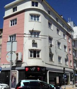 un edificio con un coche aparcado delante en Apartamentos Internacional, en Coímbra