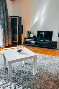 ein Wohnzimmer mit einem weißen Couchtisch und einem TV in der Unterkunft He-Ra apartment 6 with Free Netflix in Skopje