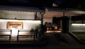 Un edificio con dos bancos y un cartel que dice "ticket del centro" en Downtown Hostel, en Luang Prabang