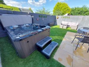 a hot tub in a backyard with a table and chairs at Hot Tub house close to Woodland and Peak District in Brimington