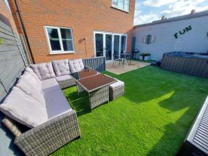 a backyard with a couch and a table and grass at Hot Tub house close to Woodland and Peak District in Brimington