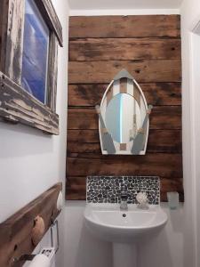 een badkamer met een wastafel en een spiegel bij Hot Tub house close to Woodland and Peak District in Brimington