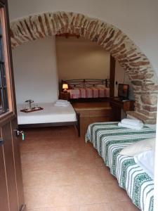 two beds in a room with a stone archway at Monitsia Traditional House in Khalkíon