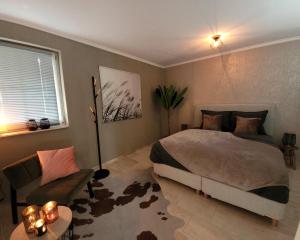 una camera con un grande letto e un divano di Secret Wellness Lonneker a Enschede