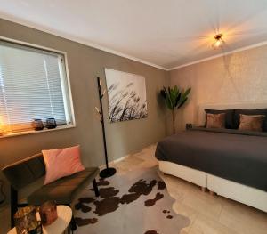 een slaapkamer met een bed, een bank en een raam bij Secret Wellness Lonneker in Enschede