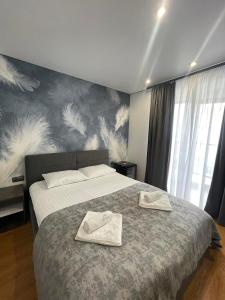 a bedroom with a bed with two towels on it at Stella in Ternopil