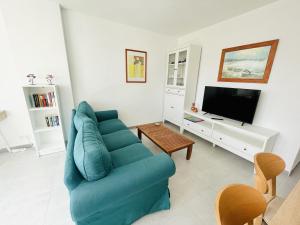 ein Wohnzimmer mit einem blauen Sofa und einem TV in der Unterkunft A552 - Cardenal 4 - 2004 Finestrat s.l. in Cala de Finestrat