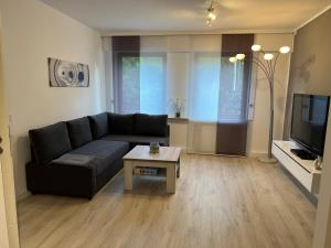 uma sala de estar com um sofá e uma mesa de centro em Ferienwohnung Poppelreiter em Solingen