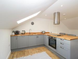a kitchen with white cabinets and wooden counter tops at High Lodge in Watchet