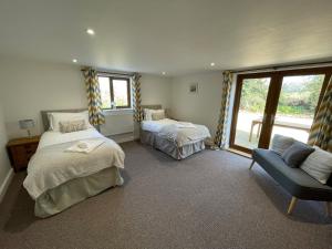 a bedroom with two beds and a couch and a window at High Lodge in Watchet