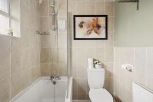 a bathroom with a tub and a toilet and a shower at Beautiful 4 Bed in Kent - Parking - Sleeps 7 in Kent