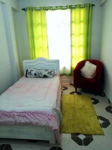 a bedroom with a bed and a chair and a window at Habitación individual IGLESIAS in Sucre