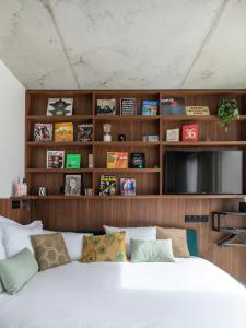 a living room with a large bed and a tv at JOST Hôtel Bordeaux Centre Gare Saint Jean in Bordeaux