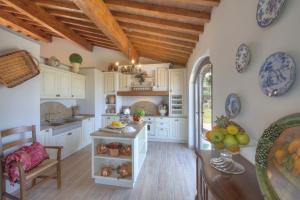 a kitchen with white cabinets and a wooden ceiling at Villa Torresassa in Montaione