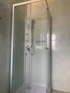 La salle de bains est pourvue d'une douche avec une porte en verre. dans l'établissement Residence Giulia, à Santa Maria Maddalena