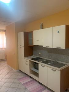 a kitchen with white cabinets and a sink at Residence Giulia in Santa Maria Maddalena