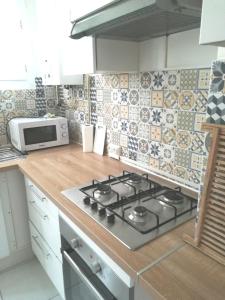 uma cozinha com um fogão e um micro-ondas em Toulon# 6 personnes# bord de mer em La Seyne-sur-Mer