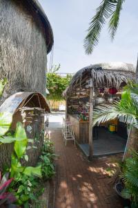 a shop with a thatched roof and a patio at Cocohut Hoi An Homestay in Hoi An