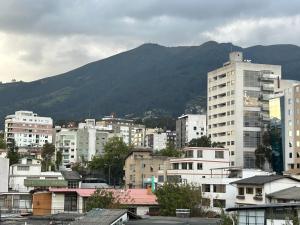 a city with buildings and a mountain in the background at IÑAQUITO GOLD in Quito