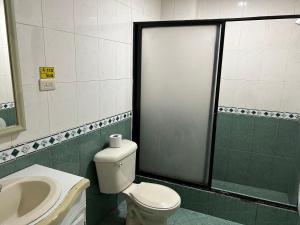 łazienka z toaletą i umywalką w obiekcie IÑAQUITO GOLD w mieście Quito
