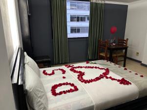 un letto con un cuore realizzato con fiori rossi di IÑAQUITO GOLD a Quito