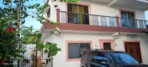a car parked in front of a house with a balcony at Casa Gacela Cozumel in Cozumel
