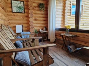 a log cabin with two benches and a table at Troya Chalets in Baba Stana