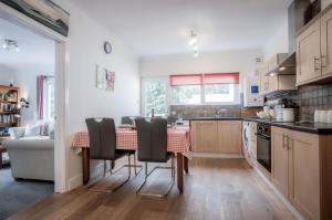 Glenvale - 2 Bedroom Apartment - Saundersfoot في ساندرزفوت: مطبخ مع طاولة وكراسي في غرفة