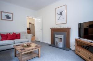 a living room with a couch and a fireplace at Glenvale - 2 Bedroom Apartment - Saundersfoot in Saundersfoot