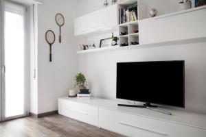 un salon avec une télévision à écran plat sur une armoire blanche dans l'établissement Appartamento Stefano, à Luino