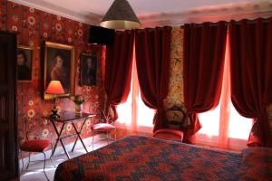 a bedroom with red curtains and a bed and a window at Hôtel De Nice in Paris