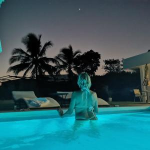 Pedasí Town的住宿－Ocean Breeze Cove - Luxury Retreat，一位晚上坐在游泳池里的女人