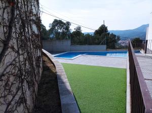 uma piscina com relva verde ao lado de um edifício em Apartament vistes al mar em Llançà