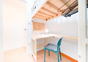 Kleines Zimmer mit einem Schreibtisch und einem blauen Stuhl. in der Unterkunft CoLiving - Lockhart Road 388 in Hongkong