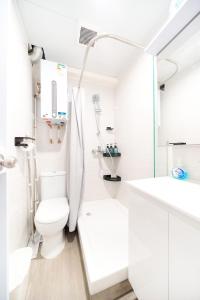 ein weißes Bad mit einem WC und einem Waschbecken in der Unterkunft CoLiving - Lockhart Road 388 in Hongkong