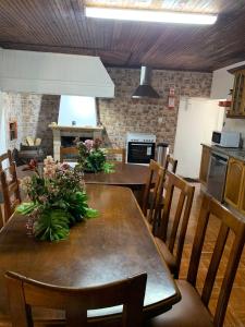 uma cozinha com uma mesa de madeira com flores em Cobal 's HOUSE em Viseu
