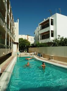 two people in a swimming pool in a building at Theonia Hotel in Kos