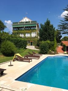 a swimming pool in front of a large house at Vila dos Castanheiros in Ferreira do Zêzere