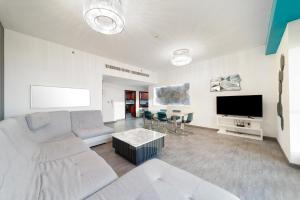 - un salon avec un canapé et une télévision dans l'établissement Elan Rimal Suites JBR Beach Sea View, à Dubaï