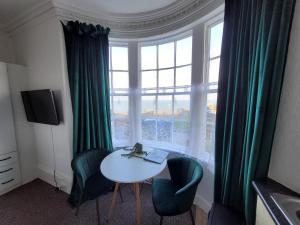 una stanza con tavolo e sedie e una grande finestra di SeaView ground floor flat fast WiFi & FREE PARKING a Scarborough