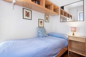 Dormitorio pequeño con cama azul y espejo en Tea apartment, en Santa Margherita Ligure