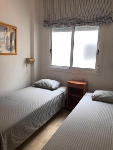 um quarto com 2 camas e uma janela em building oceanfront, torild em Calafell